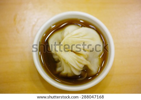 Single steamed bun in vinegar on table, up view, Chinese traditional food for breakfast.