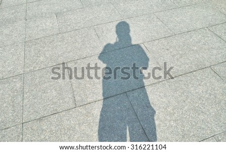Man\'s shadow on the brick ground, selfie.