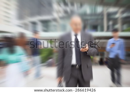 motion blur suit and tie businessman hand on mobile phone walking to work