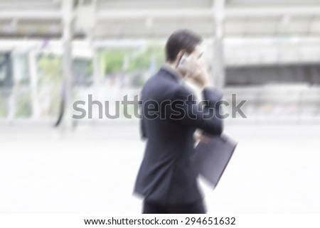 motion blur businessman on phone walking to work