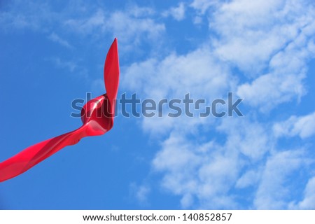 horizontal color image of sky and red art sculpture