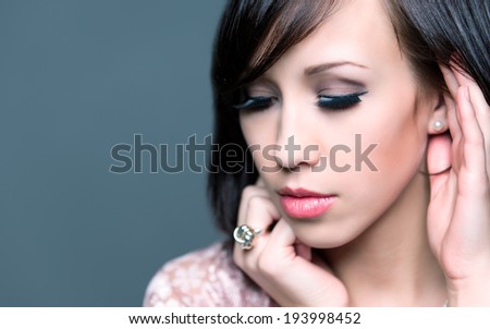 Horizontal colour image. beautiful young woman with healthy face and clean skin isolated on grey background