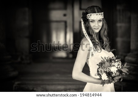 Beautiful Happy bride with wedding flowers bouquet in white dress with wedding hairstyle and makeup. Smiling woman in wedding dress waiting for groom. Pretty brunette girl bride. Jewelry and Beauty