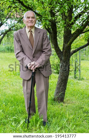 Handsome 80 plus year old senior man posing for a portrait in his garden.