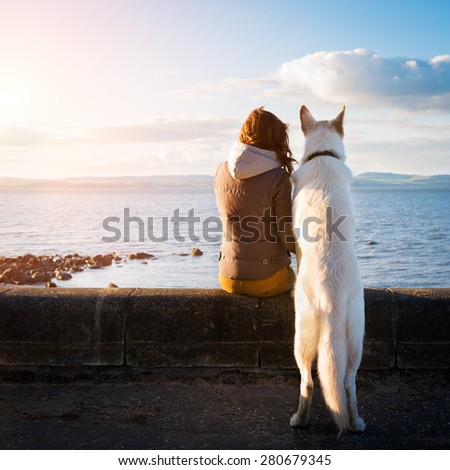 Young hipster girl with her pet dog at a seaside, colorised image
