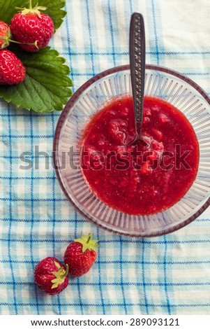 Homemade strawberry jam (marmalade). glass bowl with hot jam and fresh strawberries