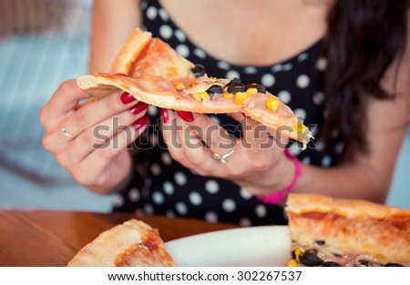 Anonymous woman enjoying pizza in restaurant