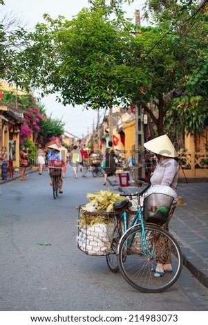 HOI AN, VIETNAM - MAY 10: An unidentified woman rides her bicycle on May 10, 2014 in Hoi An, Vietnam. Hoi An, a UNESCO World Heritage site, is a major touristic destination in Central Vietnam.