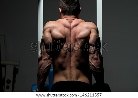 young male bodybuilder doing heavy weight exercise