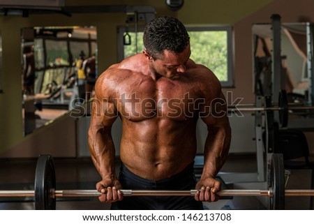 muscular man doing heavy weight exercise for biceps with dumbbell