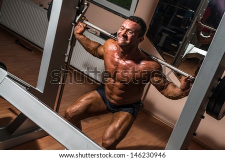 bodybuilder doing squat with barbell
