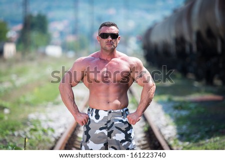 Body Builder Posing At The Railroad