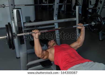 Lifting Weights. Attractive Fit Men Lying On A Weight Bench Working Out With Dumbbells