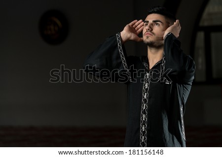 Young Muslim Guy Praying - Man Making Traditional Prayer To God While Wearing A Traditional Cap Dishdasha