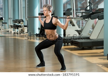 Train Hard Feel Good - Beautiful Fit Woman Doing Barbell Squats In The Gym