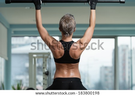 Female Athlete Doing Pull Ups - Chin-Ups In The Gym