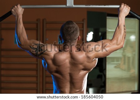Male Athlete Doing Pull Ups - Chin-Ups In The Gym