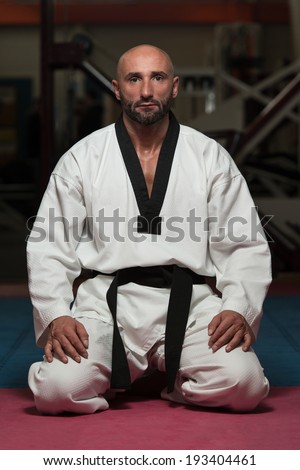 Black Belt Karate Man Sit On A Position To Start Or Finish Practicing