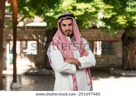 Portrait Of Young Arab Saudi Emirates Man - Young Businessman Wearing A Traditional Cap Dishdasha