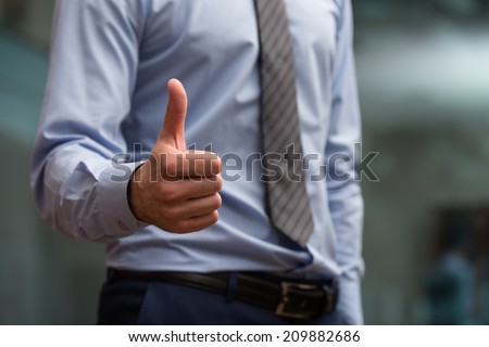 Close-Up Of A Human Hand Showing Thumbs Up On The Foreground
