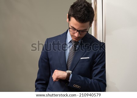 Young Businessman Looking At The Time On His Wrist Watch