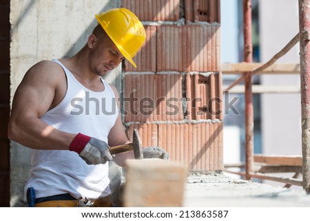 Builder Working With Hammer And Nail - A Handsome Construction Man Using A Hammer To Nail Together Wood