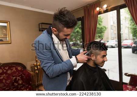 Hairdresser Making Haircut To Young Man - Handsome Young Hairdresser Giving A New Haircut To Male Customer At Parlor