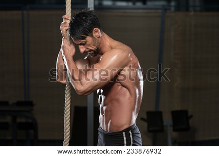 Man Resting After Fitness Rope Climb Exercise In Fitness Gym Workout