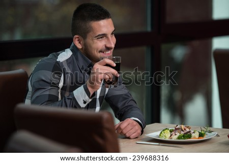 Handsome Man Eating At A Restaurant And Looking Happy