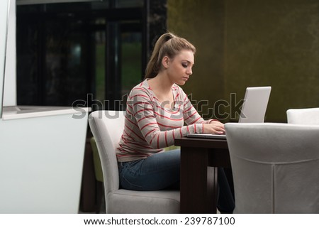Young Female Student Drinking And Having Fun With Laptop In Cafeteria