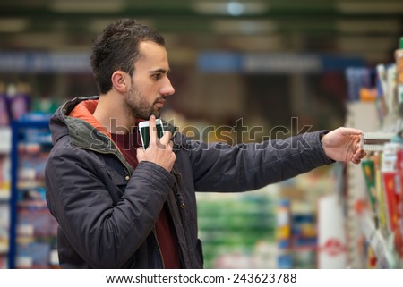 Man Using Mobile Phone While Shopping In Shopping Store