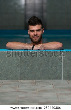 Happy Attractive Man Resting Relaxed On Edge Of Swimming Pool