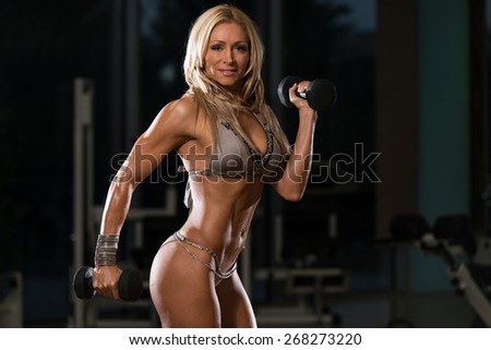 Mature Woman Working Out Biceps In Fitness Center - Dumbbell Concentration Curls
