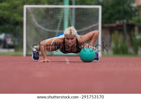 Young Woman Outdoors Performing Push Ups On Medicine Ball Bodybuilding Exercise