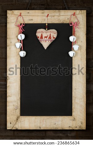 Merry Christmas and Happy New Years chalkboard blackboard tin bells and heart decoration restaurant vintage menu design on painted reclaimed wooden frame, dark brown brick wall, copy space