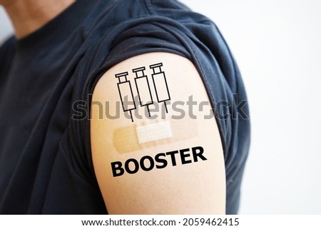 Man showing vaccinated shoulder with third shots or booster shots symbol, vaccination for COVID-19 concept