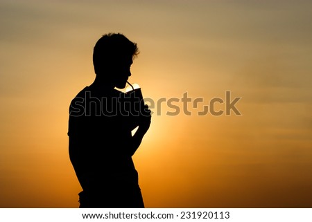 silhouette pic of a man drinking water with straw.