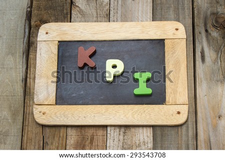 writing black slate on wooden background with KPI word; Key performance indicator