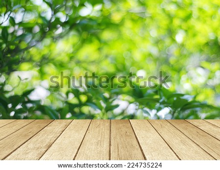 Empty perspective wood with blur green leaves bokeh background, for product display montage