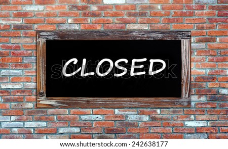 Closed word on vintage chalk board on brick wall background, closed sign