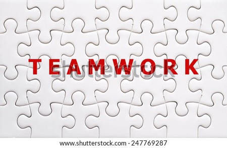 Teamwork word on white jigsaw puzzle pieces,business concept background