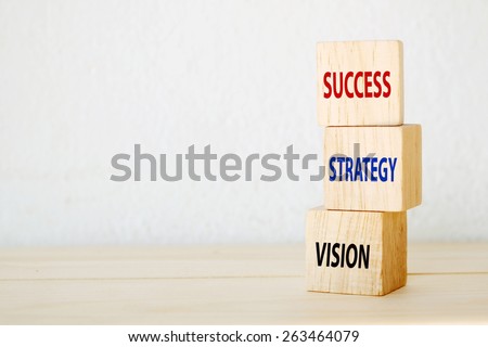 Vision, strategy and success words on three wooden cubes, step to success in business concept