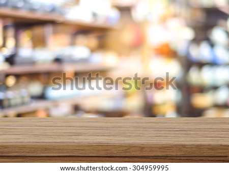 Empty table over blur product shelf in supermarket with bokeh background, product display montage