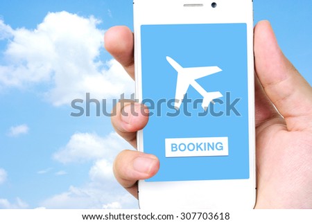 Hand holding mobile phone with airline tickets online booking on screen on screen over blue sky background, Business air travel, e-commerce and digital technology concept