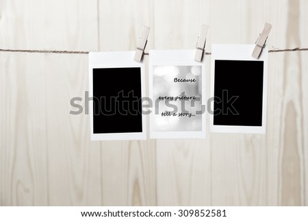 Blank polaroid frames hanging over wooden wall background with because every picture tell a story words, vintage