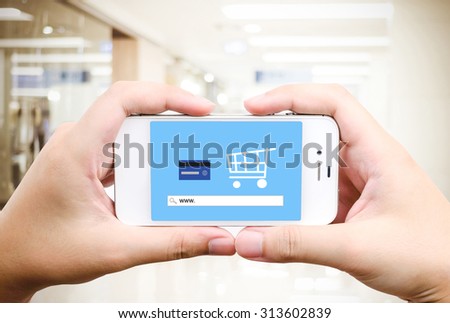 Hand holding smart phone with www. on search bar over blur store background on screen, on line shopping ,business, E-commerce, technology and digital marketing background