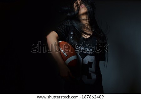 beautiful young woman, american football concept, studio shot