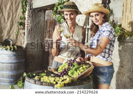 two women cheers with a glass of white wine