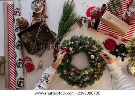 Similar – Image, Stock Photo Woman making Christmas wreath of spruce, step by step. Concept of florist’s work before the Christmas holidays.