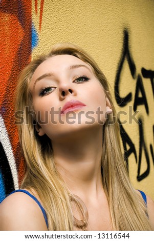 beautiful young girl in front of a graffiti wall